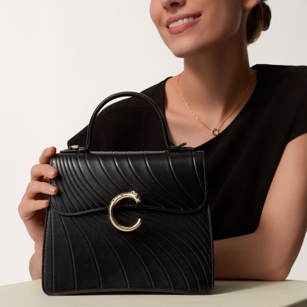 Handle bag mini model, Panthère de Cartier Black calfskin, embossed Cartier signature motif, golden finish